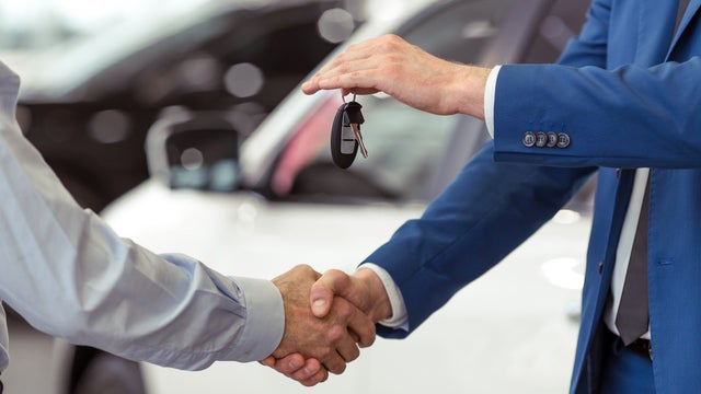 Car dealer shaking hands: Sell a car with finance owing