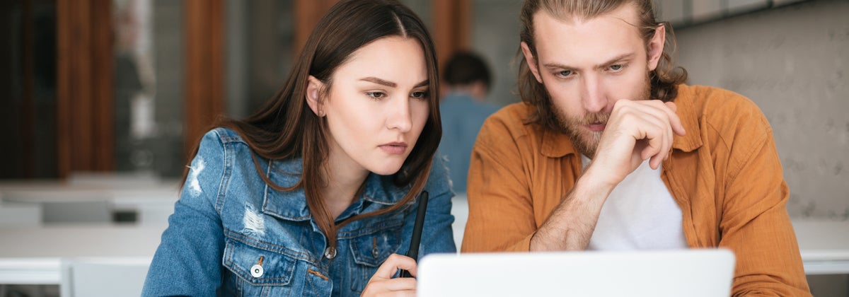 two people thinking at a laptop