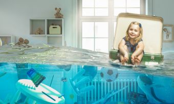 Picture of little girl floating in suitcase in her flooded bedroom