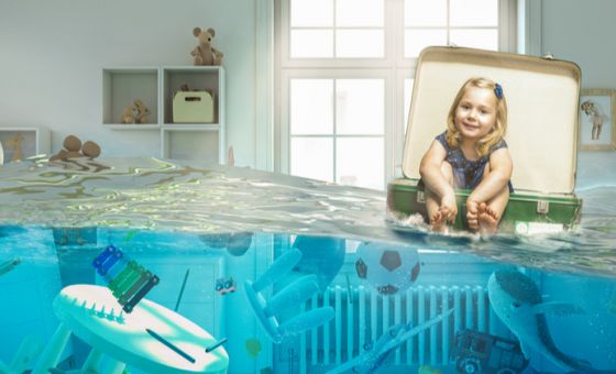 Picture of little girl floating in suitcase in her flooded bedroom