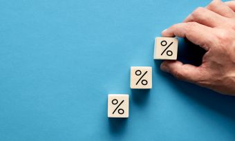 hand placing three rising wooden blocks marked with percentage symbols