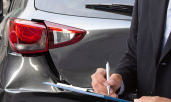 best car insurance: dented car and man filling in form